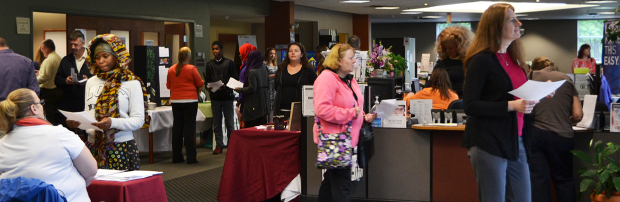 People walking around the CareerCenter, talking with employers at job fair exhibits